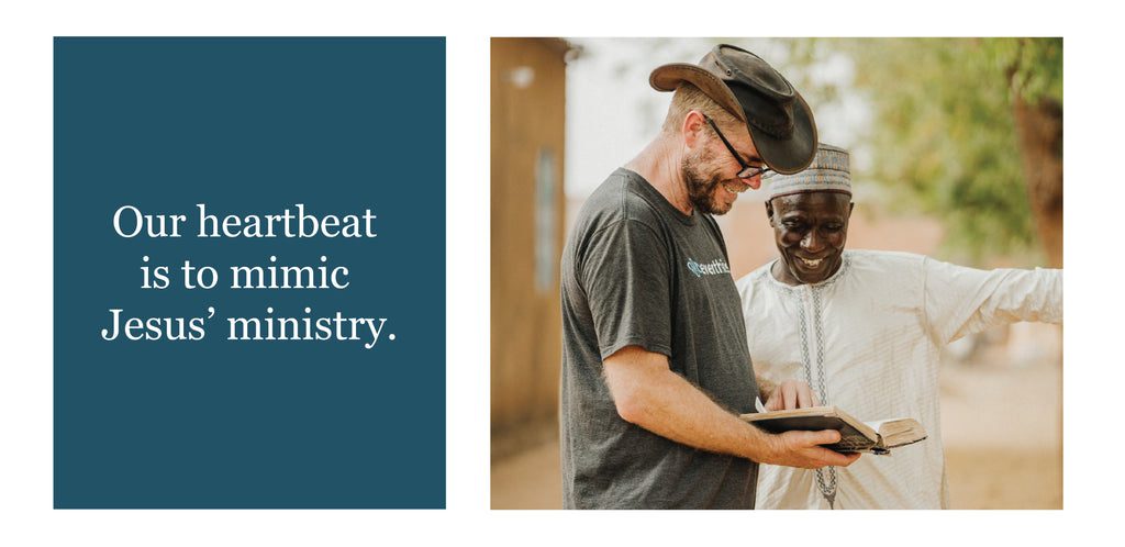 A man wearing a hat shows an open book to another smiling man in traditional attire outdoors. Next to them, text reads: Our heartbeat is to mimic Jesus’ ministry.